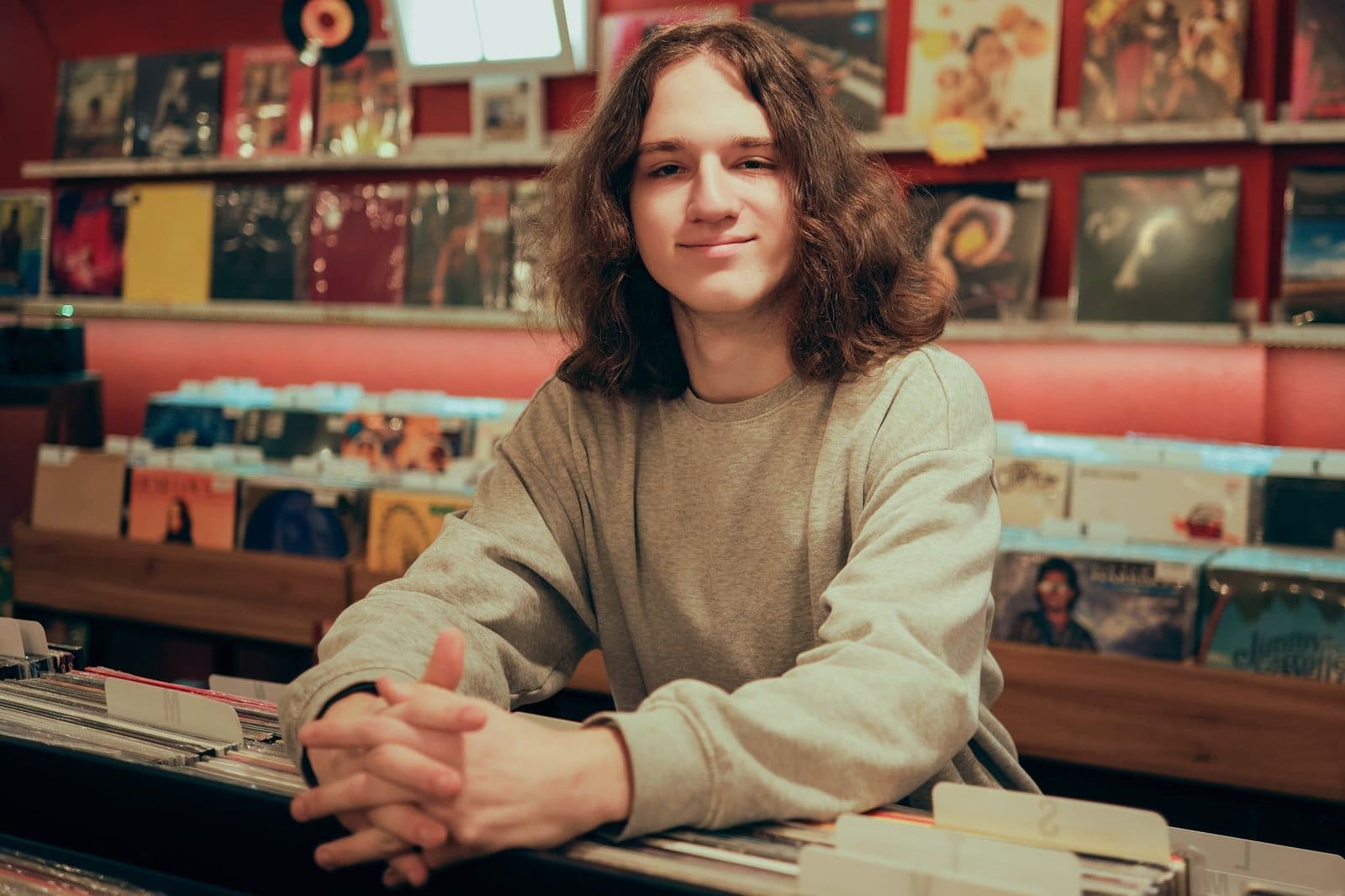 High school senior smiling in record store.